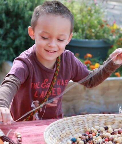 EC boy stringing beads